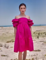 Vestido corto fucsia con escote recto y mangas abullonadas con elástico. Confeccionado en lino.
