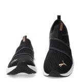 Championes de mujer Puma modelo Softride Harli Slip On, color negro con detalles en dorado. Diseño sin cordones con tiras elásticas cruzadas sobre el empeine, capellada de malla transpirable, suela blanca y amortiguación Softride.