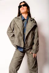 Chaqueta gris con cierre frontal y cuello solapa.