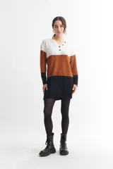 Vestido corto tejido de punto con franjas horizontales en color blanco, marrón y negro. Tiene cuello en V con botones.