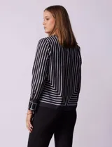 Blusa de gasa estampada con líneas verticales negras sobre fondo beige, de manga larga con puño abotonado. Espalda con abertura y botón.