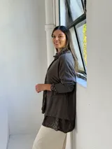 Sweater de punto color chocolate con diseño de capas, que incluye una camisa interior con estampado animal print visible en el cuello, puños y ruedo.