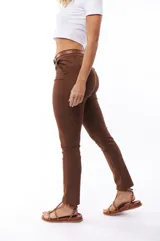 Pantalón marrón de corte skinny, con cintura alta y cinturón marrón.