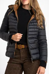 Campera reversible con diseño acolchado, cierre frontal y capucha. Un lado es de color negro y el otro de color tostado, con puños tejidos en color negro.