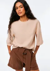 Blusa de manga corta color beige, con cuello redondo y diseño holgado.