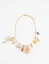 Collar dorado con cadena de eslabones y dijes colgantes de diferentes formas y colores con motivos marinos: conchas, caracoles y estrellas de mar.