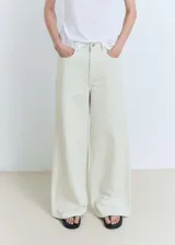Pantalón de jean estilo wide leg, de tiro medio, con cierre frontal de cremallera y botón, trabillas para cinturón y diseño de cinco bolsillos.