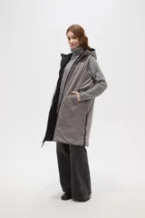 Chaleco largo acolchado color marrón, con diseño de rombos, cierre frontal completo y capucha ajustable con cordones.