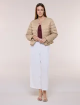 Campera puffer corta de diseño reversible y liviano, marca Michael Kors. Cuenta con acabado resistente al agua, diseño acolchado con matelaseado horizontal, cuello redondo a la base sin solapa ni capucha, cierre frontal completo con botones de presión metálicos, bolsillos laterales funcionales y ribetes a tono. Largo a la cintura y empacable en su propia bolsa de guardado.