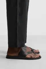 Sandalia de cuero negra con dos tiras anchas en el empeine y tira para el dedo gordo.