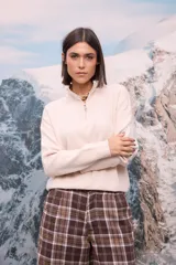 Buzo de tejido extra suave en color blanco, con cuello alto y cierre frontal parcial. Presenta mangas largas con puños ajustados y diseño de corte holgado.