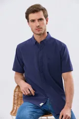 Camisa de manga corta confeccionada en mezcla de lino y algodón, color beige, con cuello camisero abotonado, bolsillo frontal en el pecho y cierre de botones.