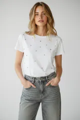 Remera de algodón color gris oscuro con cuello redondo y mangas cortas, decorada con pequeñas cuentas esféricas en tonos negro y plateado distribuidas por toda la prenda.