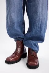 Borcegos de cuero color marrón con cierre frontal y suela track negra.