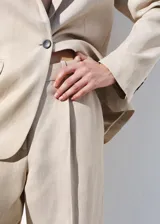 Pantalón de vestir de tiro medio, corte recto y largo, confeccionado en mezcla de lino y viscosa. Cuenta con trabillas en la cintura, dos bolsillos laterales y cierre frontal con gancho y cremallera.