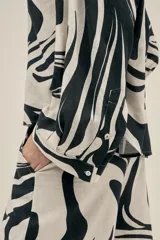 Camisa de manga larga con estampado abstracto en blanco y negro, de corte holgado.