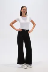 Pantalón jean negro de corte ancho y tiro alto, con cierre de botón y cremallera.