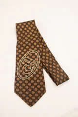 Corbata de poliéster color borgoña con estampado geométrico y logo de la marca serigrafiado en blanco.