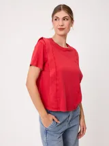 Remera de manga corta color rojo, de corte holgado, con cuello redondo y costuras decorativas frontales.
