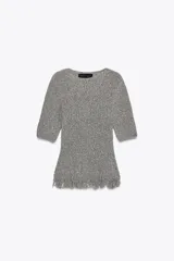 Jersey de punto gris jaspeado, de manga corta y escote redondo. El bajo presenta un acabado deshilachado o con flecos.