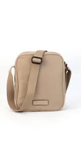 Morral de tela impermeable color negro, de forma rectangular y diseño compacto. Cuenta con correa ajustable para llevar al hombro o cruzado, y múltiples compartimentos con cierre, incluyendo un bolsillo frontal vertical con cierre.