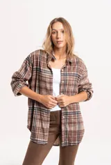 Camisa de corte oversize con estampado de cuadros escoceses en tonos marrones y negros. Presenta cuello clásico, cierre frontal con botones y mangas largas con puños.
