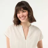 Blusa de manga corta con cuello en V y diseño a rayas verticales finas. Presenta un corte holgado y fluido.