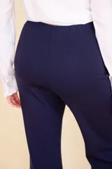 Pantalón de vestir color beige, de tela suave al tacto, con corte Oxford, cierre invisible y pinzas verticales.