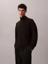 Remera de manga larga con cuello alto tipo tortuga, confeccionada en tejido de punto ponte. Presenta un diseño minimalista con logo de la marca bordado discretamente en el cuello.