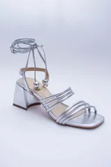 Sandalias doradas con taco cuadrado y tiras finas que se atan al tobillo. Capellada, forro y plantilla 100% de cuero.