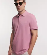 Remera polo de manga corta color verde militar, confeccionada en algodón peruano con cuello convencional y cierre de botones.