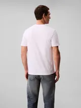 Remera Calvin Klein de manga corta y cuello redondo, color blanco, con estampado gráfico de monograma rojo en el pecho.