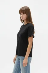 Remera blanca de algodón, de corte ajustado, con cuello redondo y mangas cortas terminadas con volados delicados.