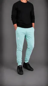 Pantalón tipo jogger color turquesa, con ajuste elástico en los tobillos, bolsillos laterales y logo bordado en la pierna derecha.