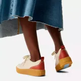 Sneakers de plataforma baja Sorel Ona Ave Low, color blanco con detalles en naranja en el talón, suela de goma marrón texturizada y detalles en celeste en la lengüeta.