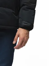 Campera puffer con capucha, de diseño bicolor en tonos gris topo y negro. Presenta cierre frontal con solapa de botones, bolsillos laterales y ajuste en los puños.