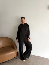 Conjunto de dos piezas compuesto por un buzo con capucha de corte holgado y mangas largas, y un pantalón de corte recto y tiro alto. Ambas prendas son de color marrón liso.