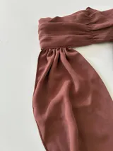 Top marrón con cuello halter y espalda descubierta, que se ata en la cintura.