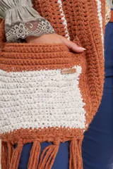 Pashmina tejida a mano en crochet, con diseño de rayas verticales en color crema y marrón. Presenta terminaciones con flecos en el ruedo y una textura acanalada distintiva.