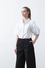 Pantalón wide leg de corte sastrero, color negro, con cintura de tiro medio y diseño de pernera amplia y relajada.