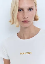 Camiseta de punto de algodón blanca, de corte recto, con cuello redondo, manga corta y el logo de Mango estampado en el pecho en tono dorado.