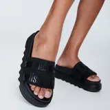 Sandalias plataforma Melissa modelo Cozy Slide M-Lover Bold Platform, color negro, con faja ancha superior con logo en relieve y suela track elevada.