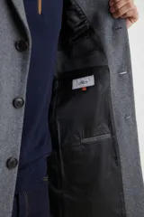 Sobretodo 3/4 de paño, color gris oscuro, con cuello solapa, cierre frontal de botones, manga larga y bolsillos laterales de ribete.