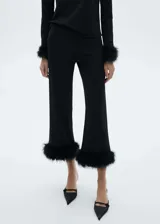 Pantalón de tiro medio y diseño crop recto, confeccionado en tejido fluido con detalle de plumas de pavo en el ruedo.