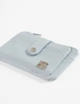 Tarjetero monedero de cuero vegano color celeste claro, con cierre a presión en solapa frontal y cierre de cremallera superior para monedas.