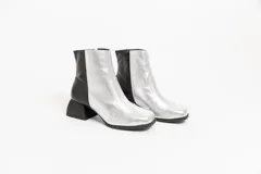 Botas cortas de cuero negro, con punta cuadrada y cierre lateral.