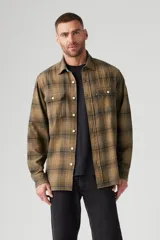 Camisa de hombre a cuadros color marrón y negro, de corte clásico, con cuello camisero, cierre frontal con botones, mangas largas con puños abotonados y dos bolsillos con solapa abotonada en el pecho.