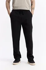 Pantalón de jogging color beige, confeccionado en algodón y poliéster, con cintura elástica y cordón ajustable. Diseño clásico sin puño en los tobillos.