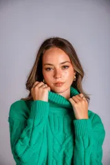 Polera verde esmeralda de tejido de punto trenzado, con cuello alto y corte ajustado.