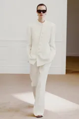 Pantalón de tiro medio de ZARA Woman Collection confeccionado en hilatura de viscosa. Cuenta con cintura con trabillas, bolsillos laterales, raya planchada y pierna recta con bajo asimétrico y aberturas. Cierre frontal con cremallera, botón y ganchos metálicos.